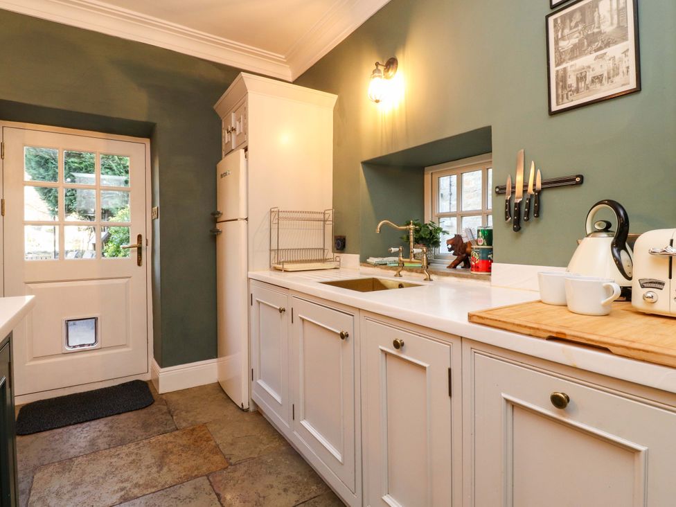 A kitchen with a sink and refrigerator at Devonshire House in Settle