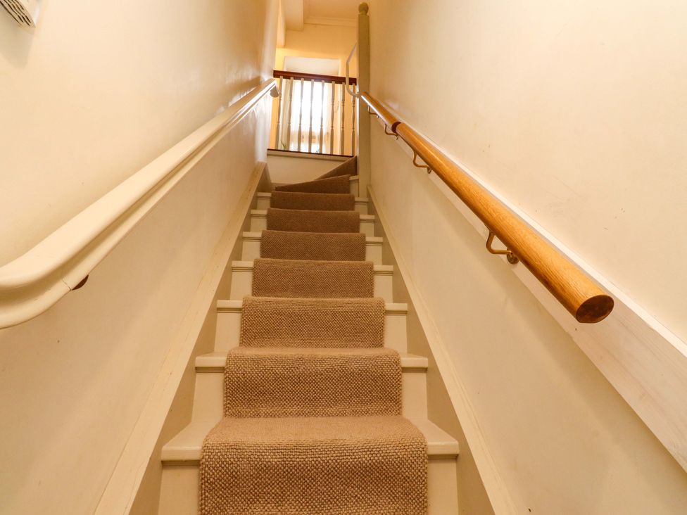 A staircase with carpet and handrail at Devonshire House in Settle