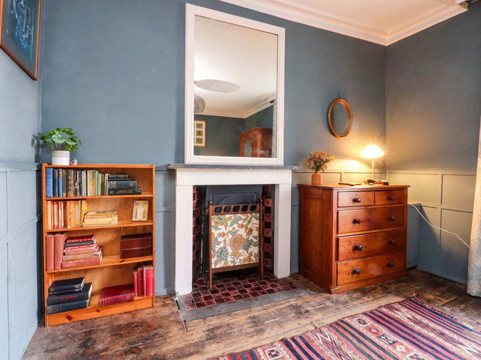 A sitting room with a bookshelf and fireplace at Devonshire House in Settle
