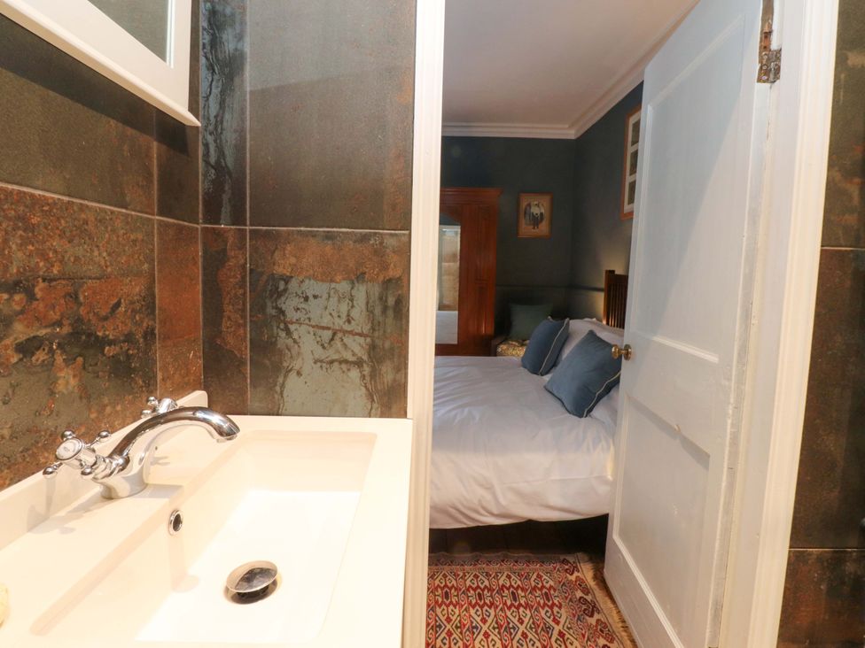 A bathroom with a sink and a view of a bedroom at Devonshire House in Settle