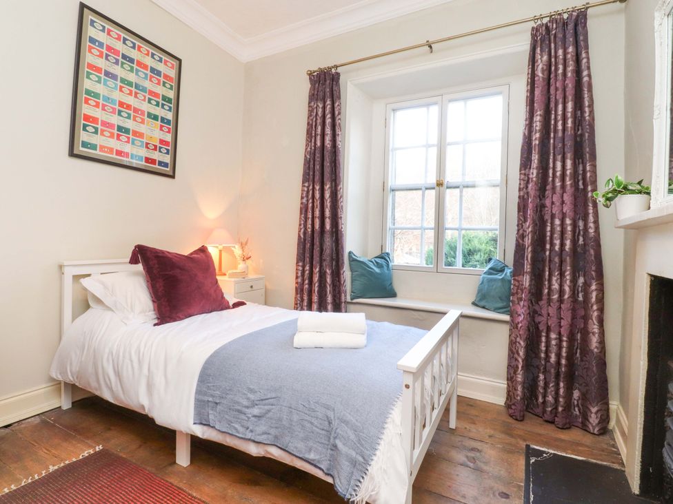A bedroom with a bed and window at Devonshire House in Settle