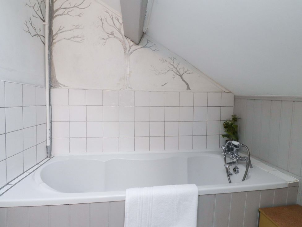 A bathroom featuring a bathtub with a faucet at Devonshire House in Settle