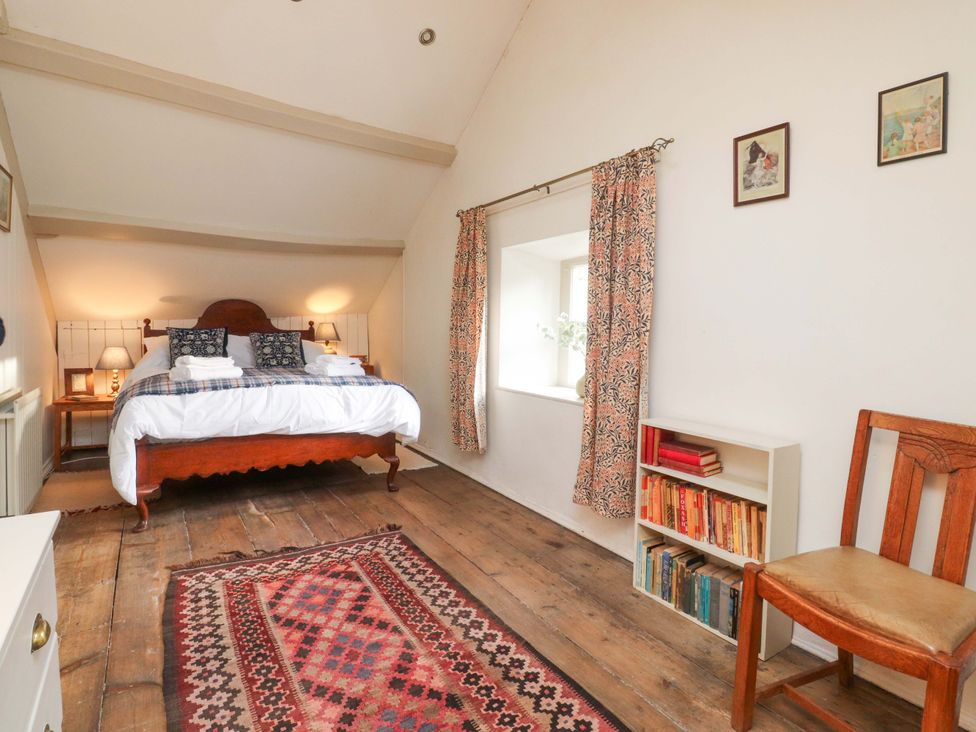 A bedroom with a bed and bookshelf at Devonshire House in Settle