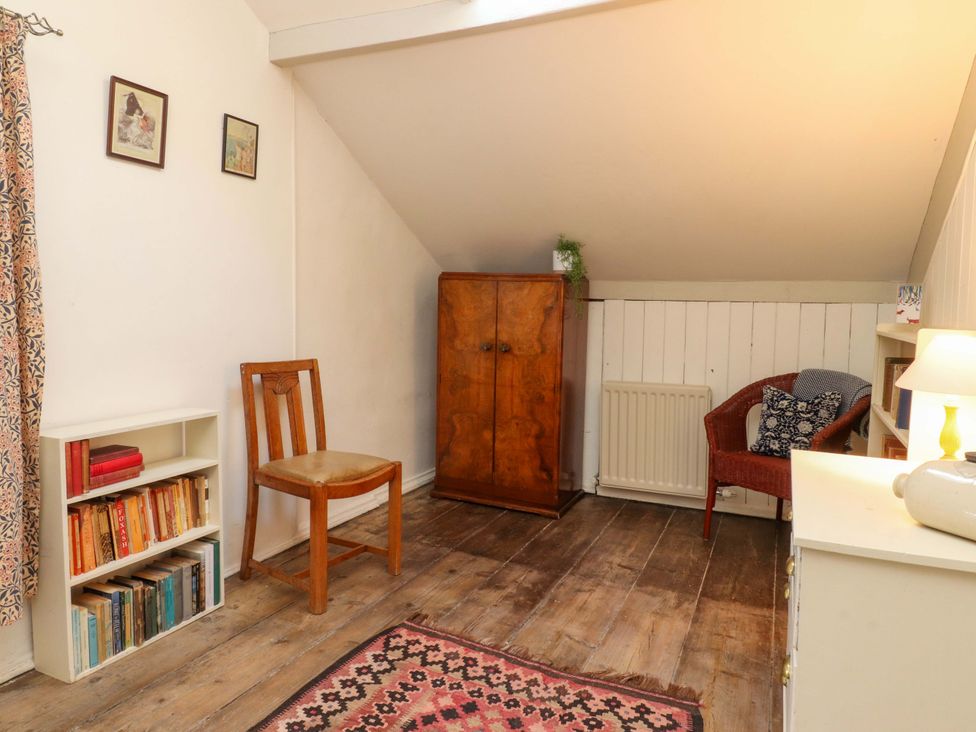 A room with a chair and bookshelf at Devonshire House Settle