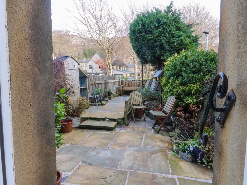 A garden with a stone pathway and seating at Devonshire House in Settle
