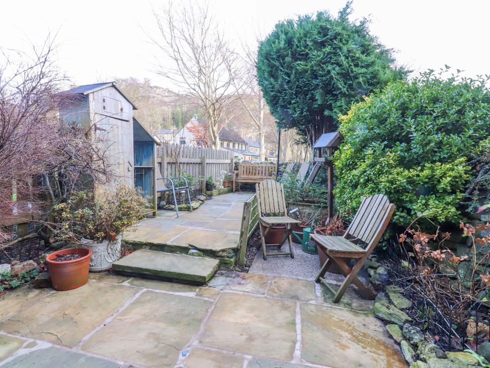 A garden with a stone pathway and wooden chairs at Devonshire House Settle