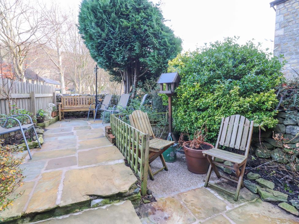 A garden with chairs and a bird feeder at Devonshire House Settle