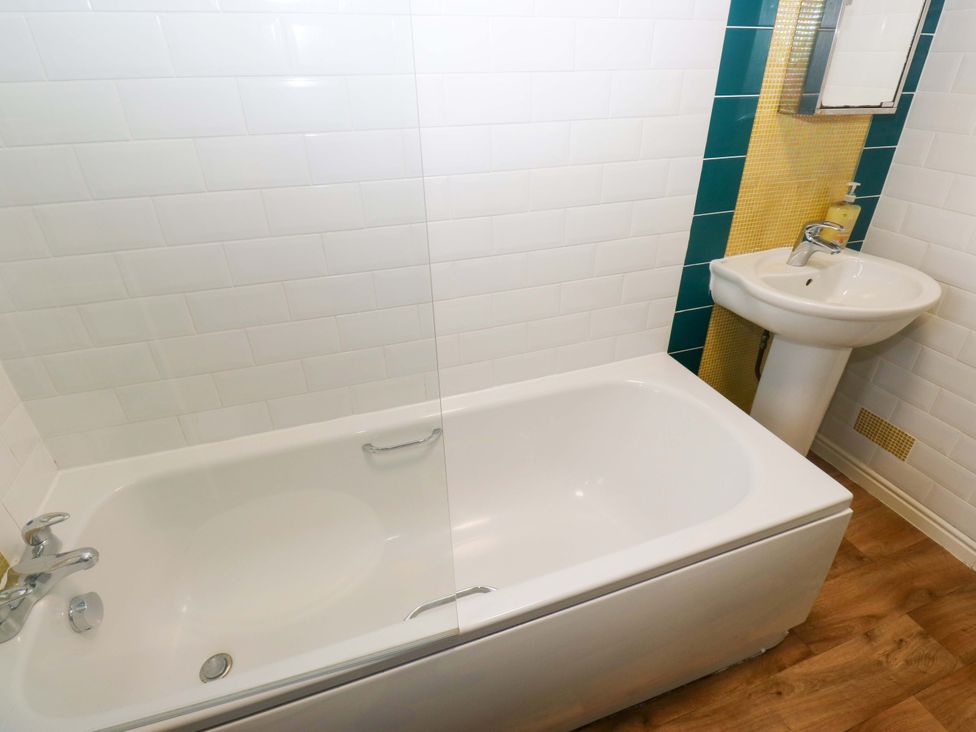 A bathroom with a bathtub and a washbasin at Cottage Holiday Home in Huddersfield