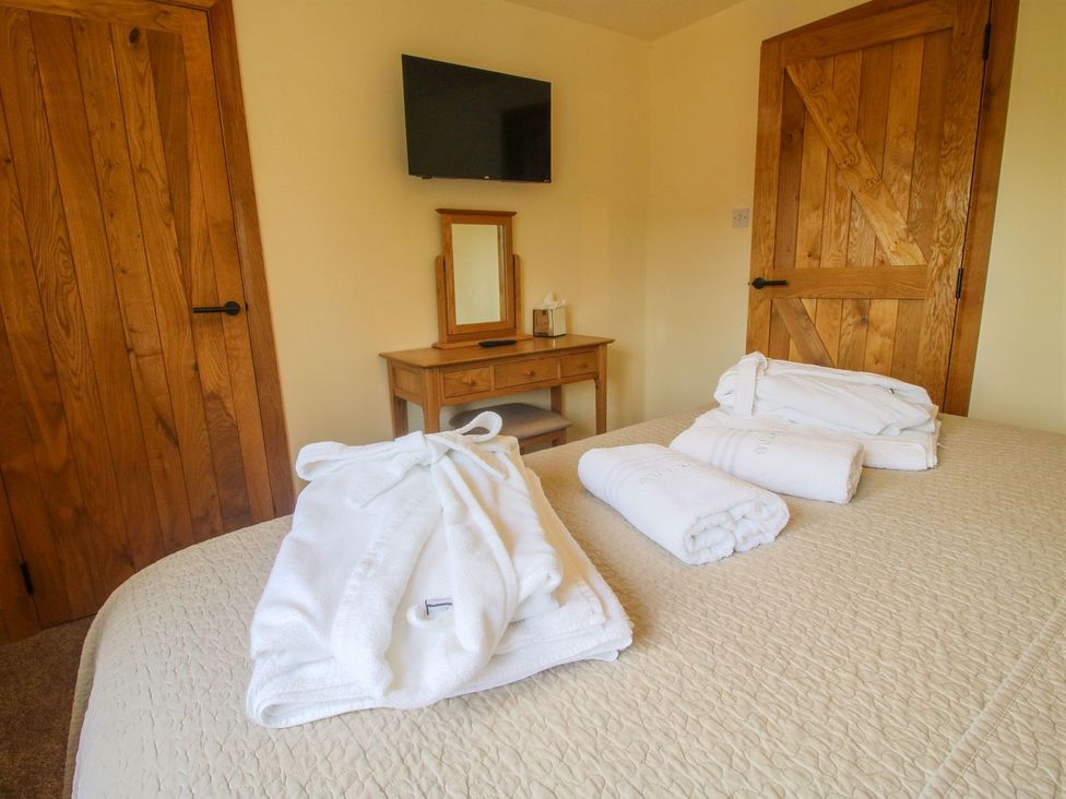 A bedroom with towels on a bed and a television at 1 Clarkes Lane St Martins