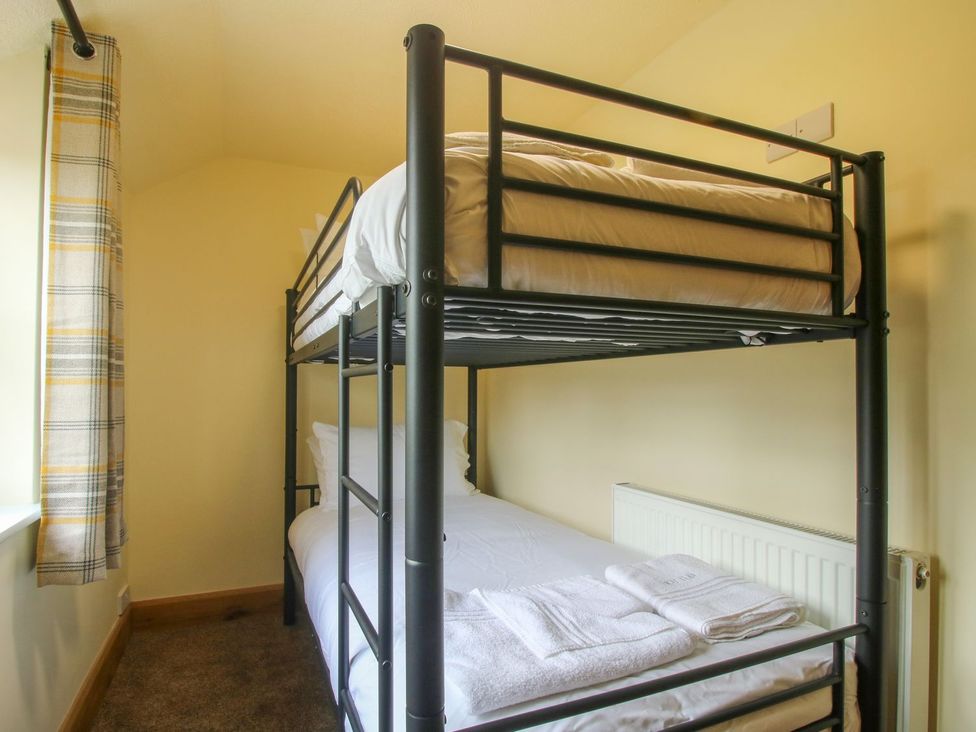 A bedroom with a bunk bed and single bed at 1 Clarkes Lane St Martins