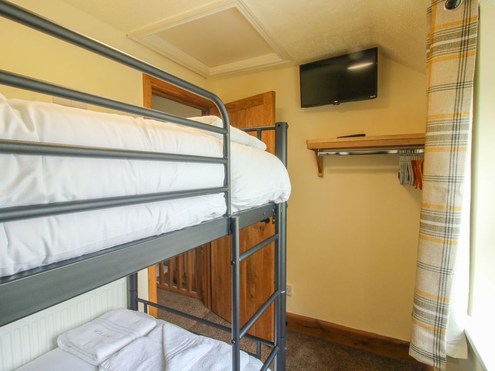 A bedroom with a bunk bed and a television at 1 Clarkes Lane St Martins