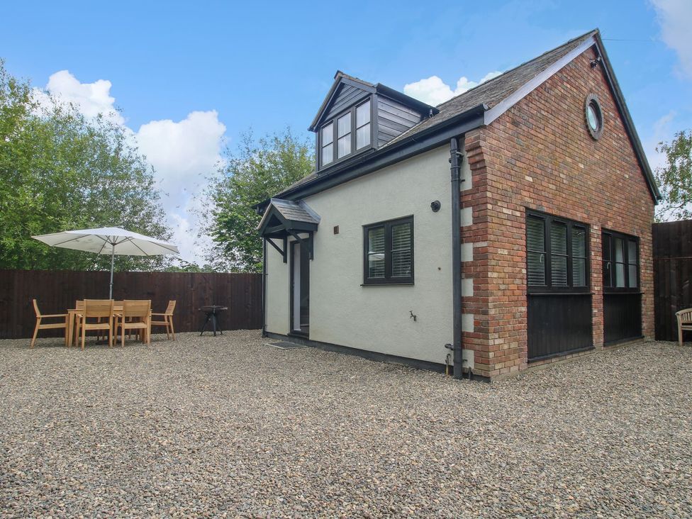 A house with a table and chairs under an umbrella at 1 Clarkes Lane St Martins