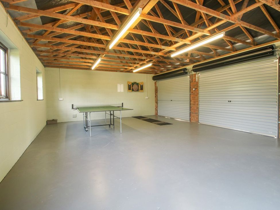 A garage with a ping pong table and a darts board at 1 Clarkes Lane St Martins