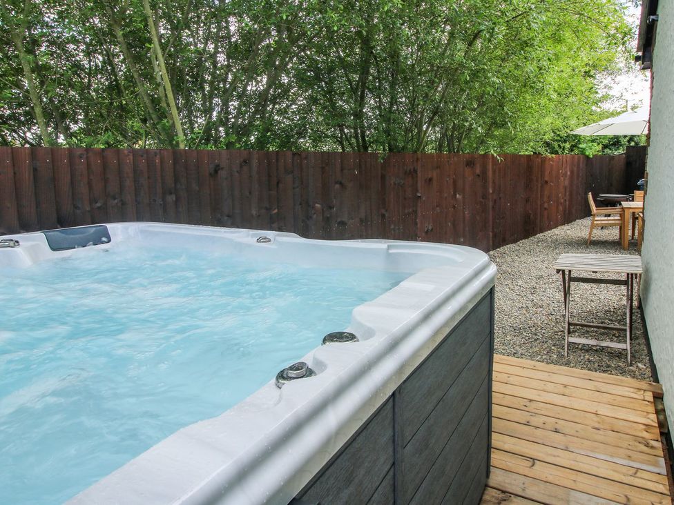 An outdoor area with a hot tub and garden furniture at 1 Clarkes Lane in St Martins