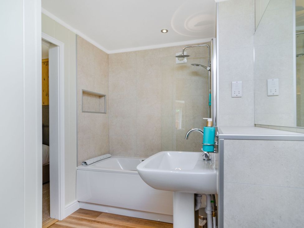 A bathroom with a bathtub and sink at The Kingscliffe (Pet) Kings Cliffe