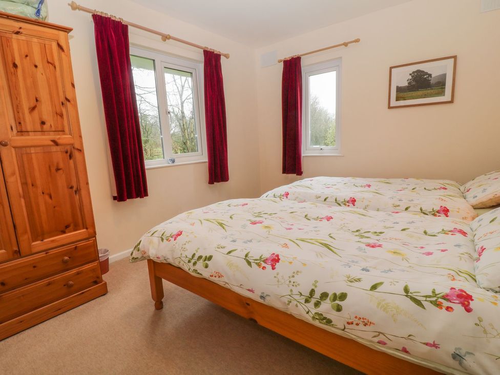 A bedroom with a bed and wardrobe at Orchard End in Launceston