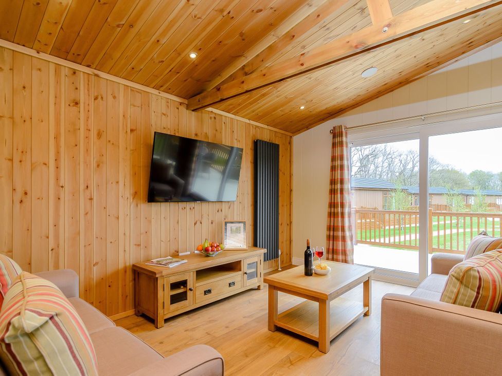 A living room with a television and coffee table at The Sutton in Kings Cliffe