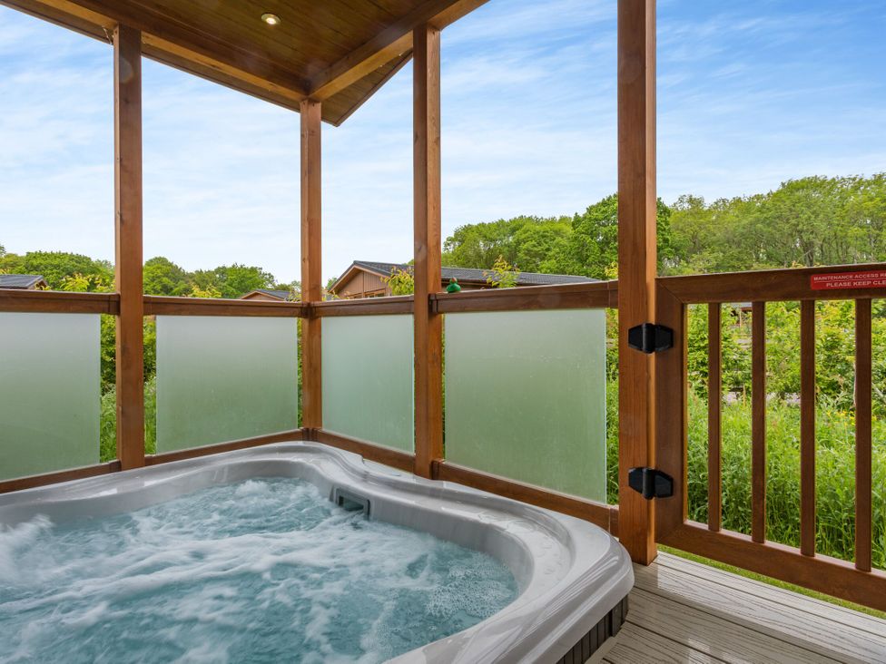 A hot tub surrounded by wooden railing in an outdoor area at The Chesterton in Kings Cliffe