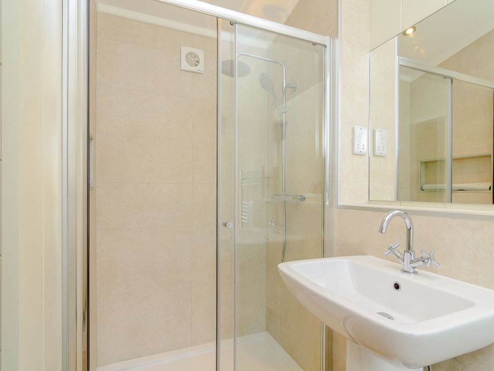A bathroom with a shower and washbasin at The Chesterton (Pet) Kings Cliffe