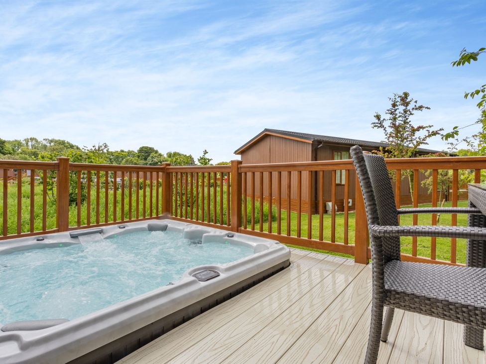 A hot tub and chairs on a deck at The Nassington (Pet) in Kings Cliffe
