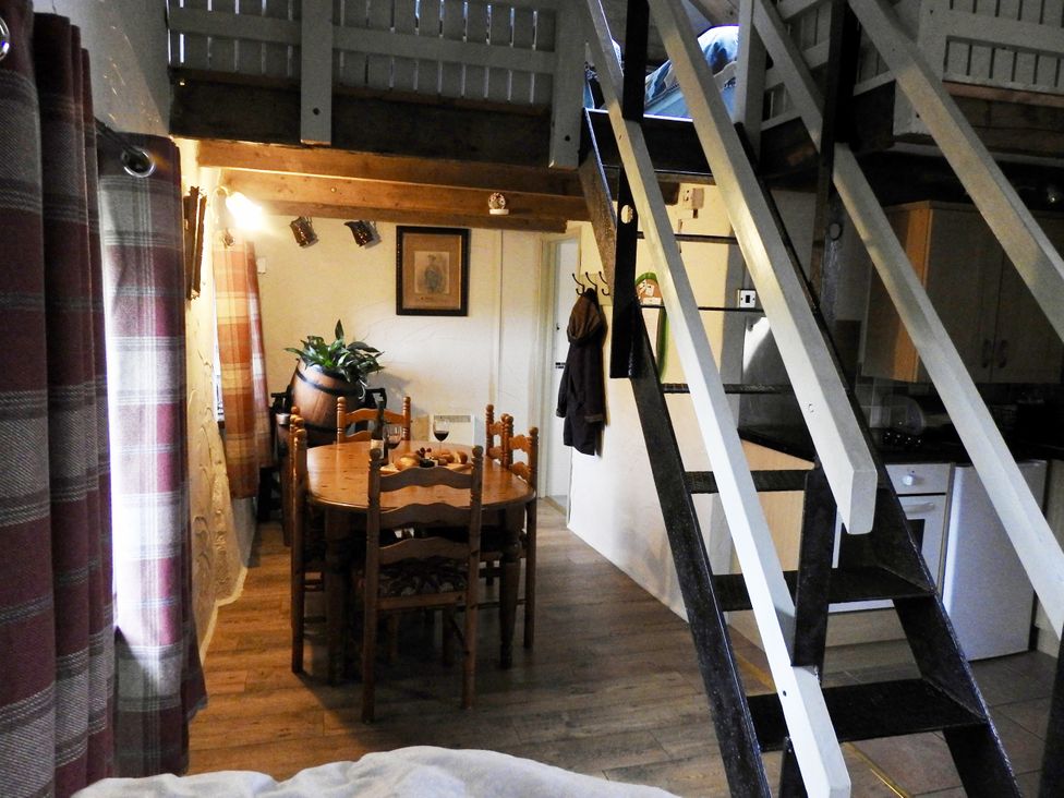 A dining room with a table and chairs at Ramsgrove in Swansea