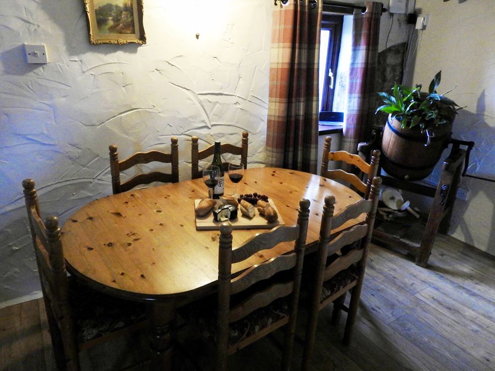 A dining room with a wooden table and chairs at Ramsgrove in Swansea