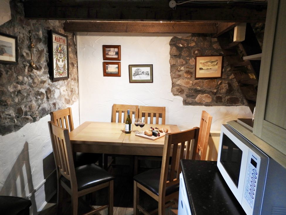 A kitchen with a wooden table and chairs at Ramsgrove in Swansea