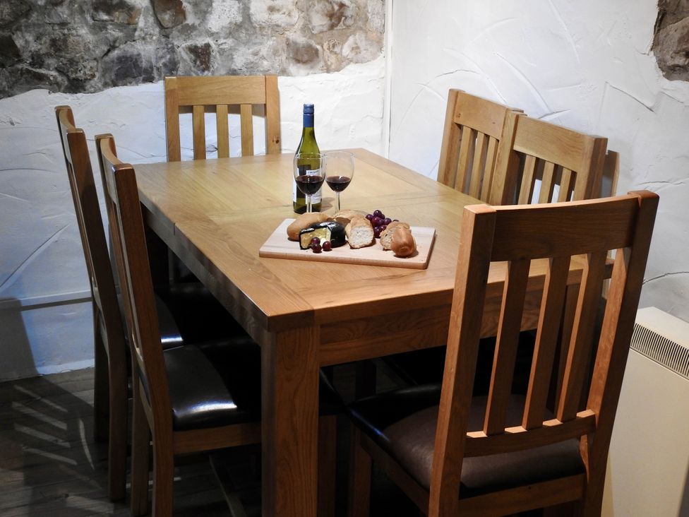 A dining room with a wooden table and chairs at Ramsgrove Swansea