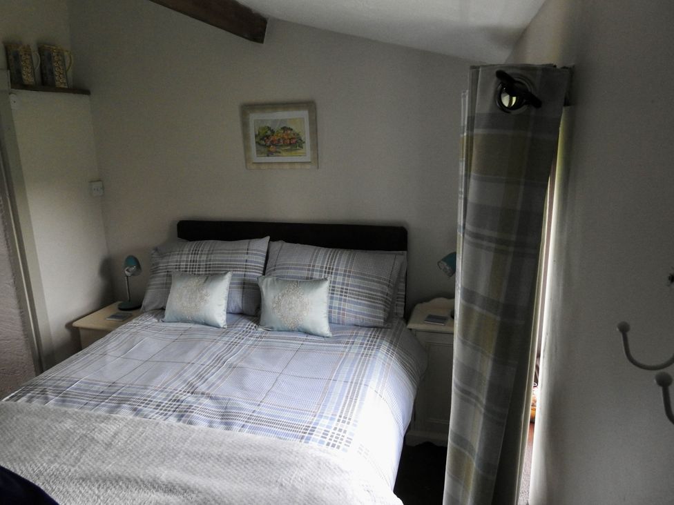 A bedroom with a double bed and bedside lamp at Ramsgrove in Swansea
