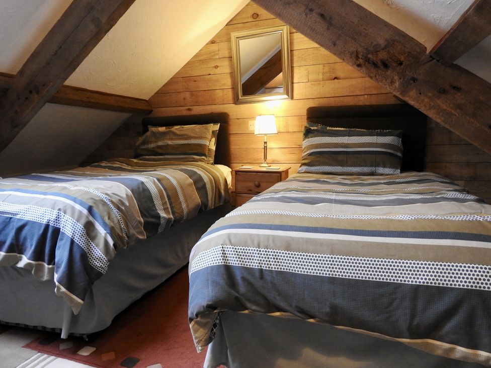 A bedroom with two beds and a lamp at Ramsgrove in Swansea