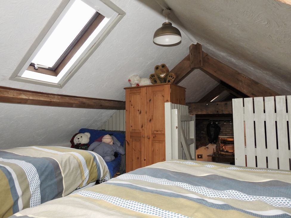 A bedroom with two beds and a wardrobe at Ramsgrove Swansea