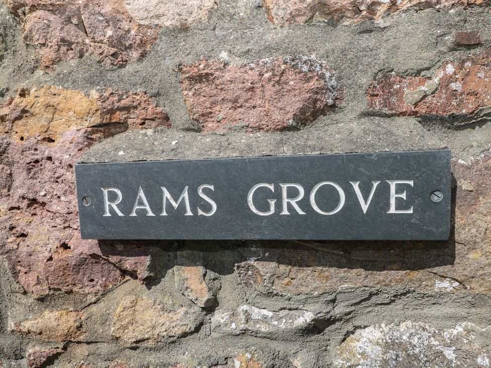 A sign that reads Rams Grove on a stone wall at Ramsgrove in Pilton