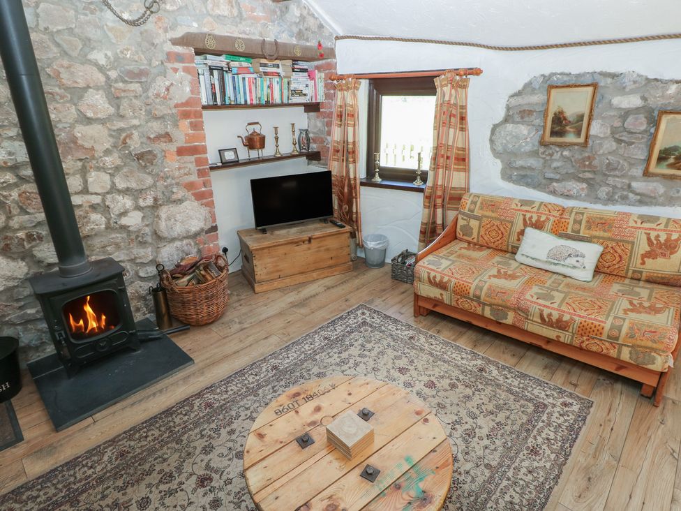 A living room with a wood stove and a sofa at Ramsgrove in Pilton