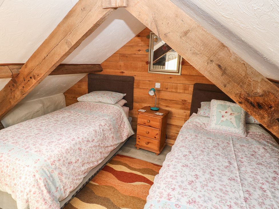 A bedroom with two beds and a nightstand at Ramsgrove in Pilton