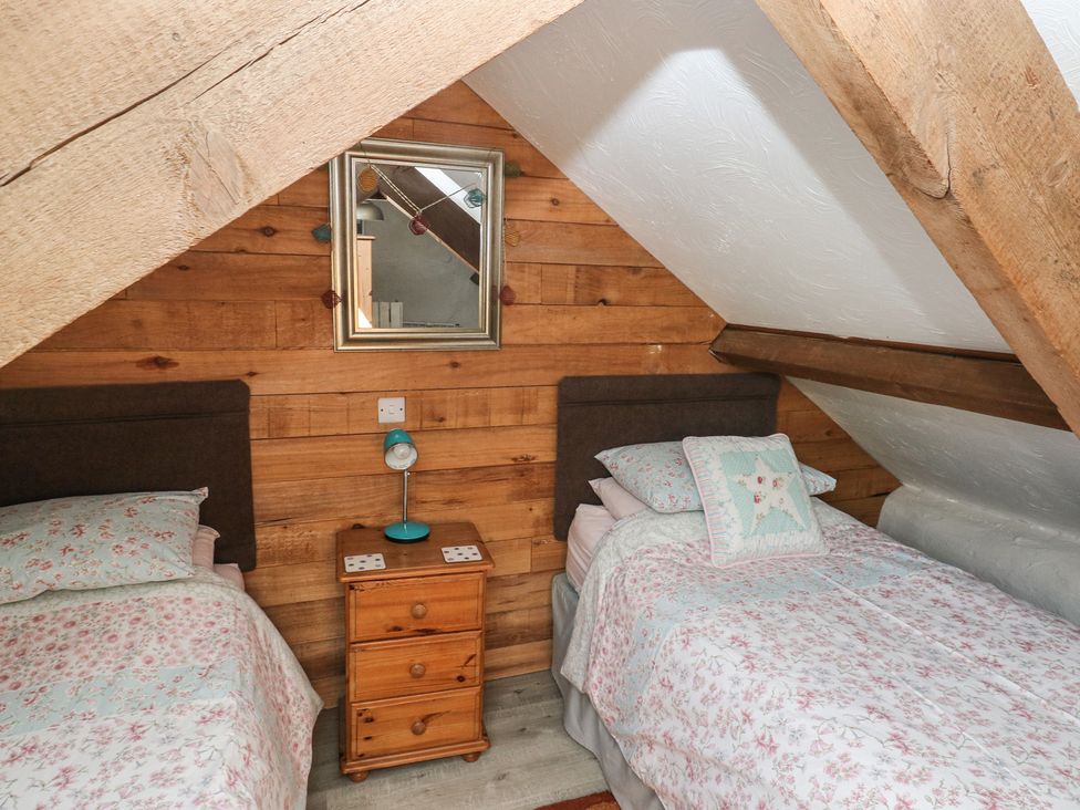 A bedroom with two beds and a bedside table at Ramsgrove in Pilton