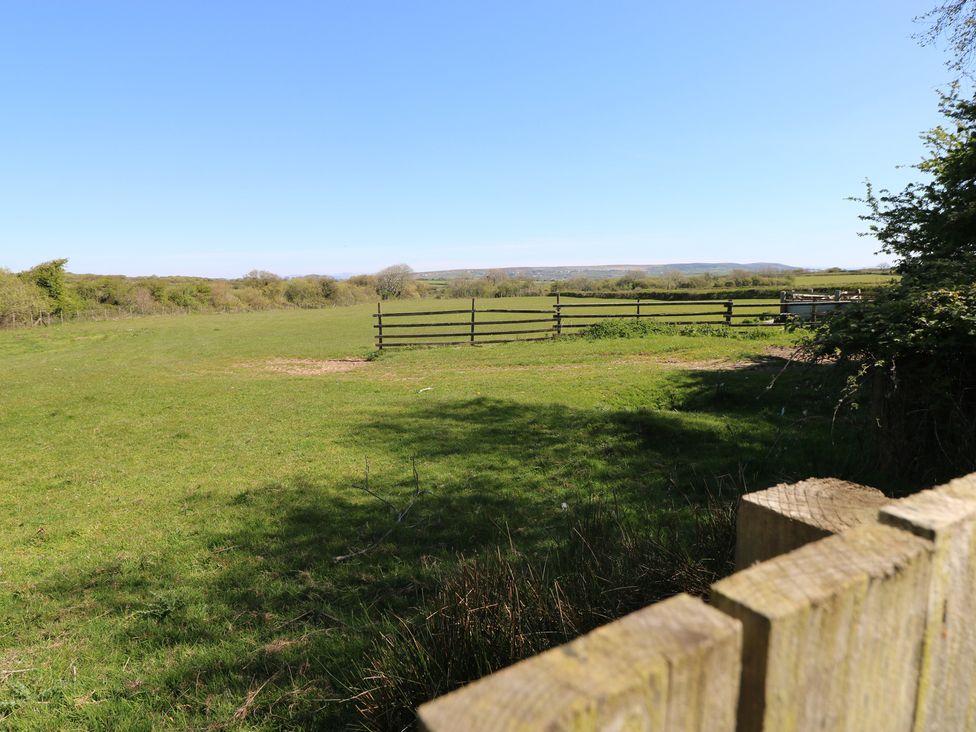 A field with a wooden fence and trees at Ramsgrove in Pilton