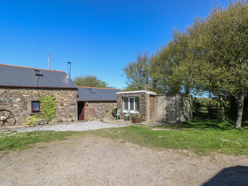 A stone building with a window and gravel area at Ramsgrove in Pilton