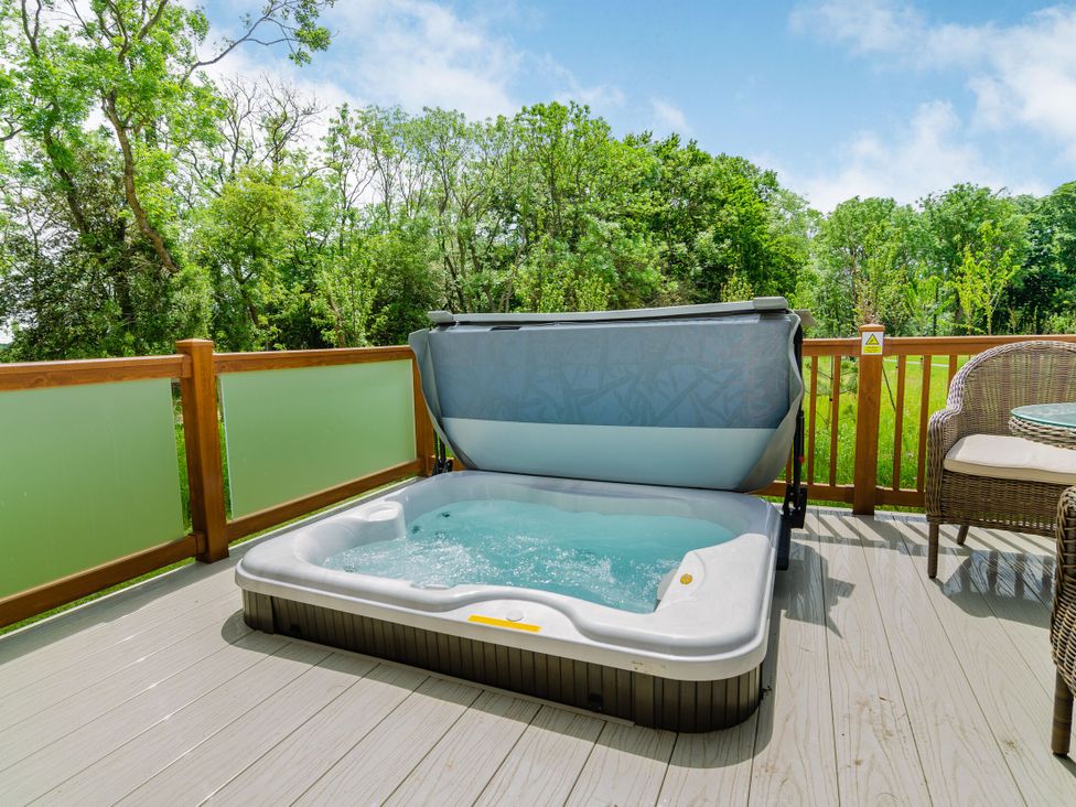 A hot tub on a deck with seating at The Wansford in Kings Cliffe
