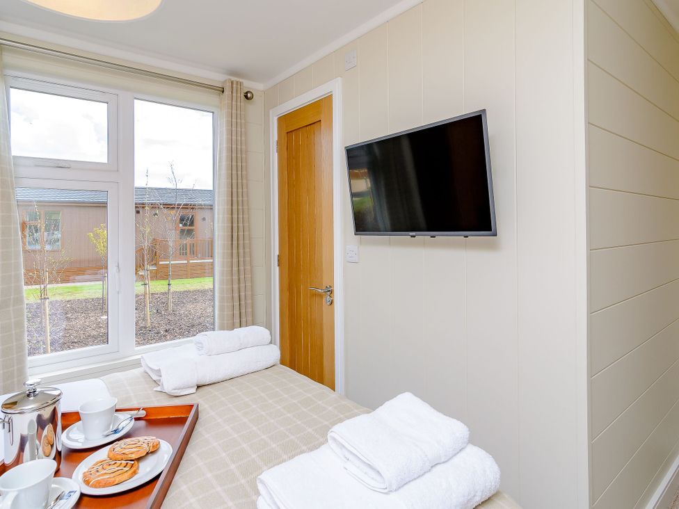 A bedroom with towels and refreshments on a tray at The Ailsworth (Pet) Kings Cliffe