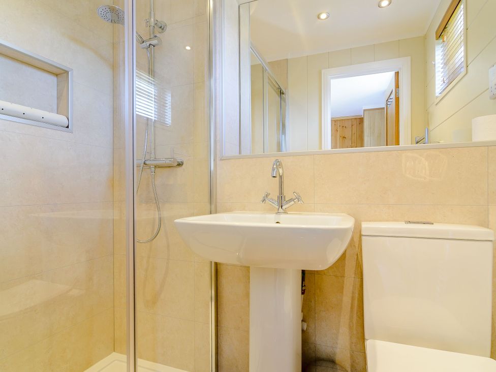 A bathroom with a shower, sink, and toilet at The Ailsworth (Pet) in Kings Cliffe