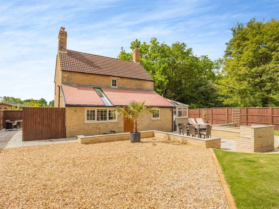 An outdoor space with a house, patio area, and seating at The Cottage in Kings Cliffe