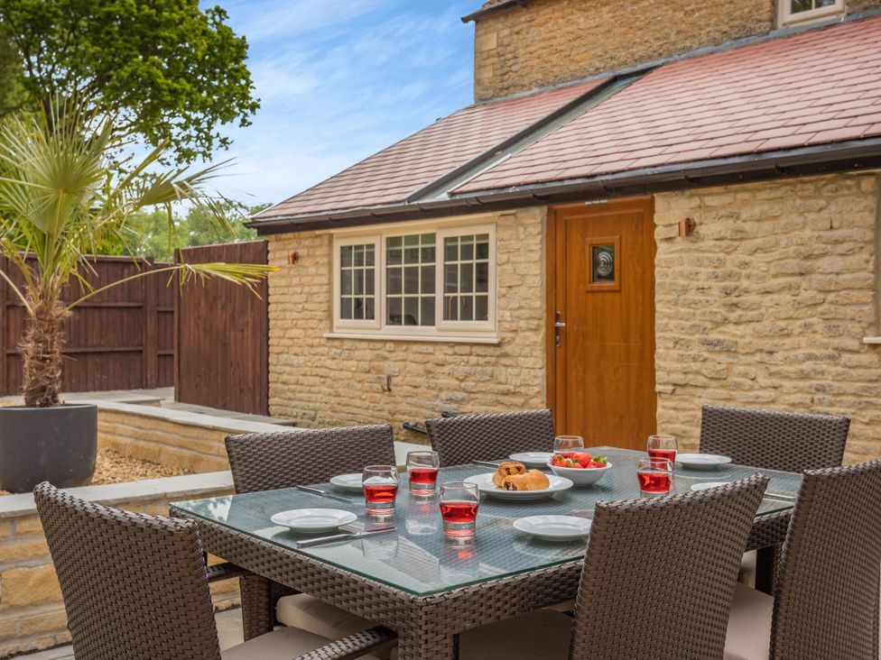 An outdoor dining area with a table and chairs at The Cottage in Kings Cliffe