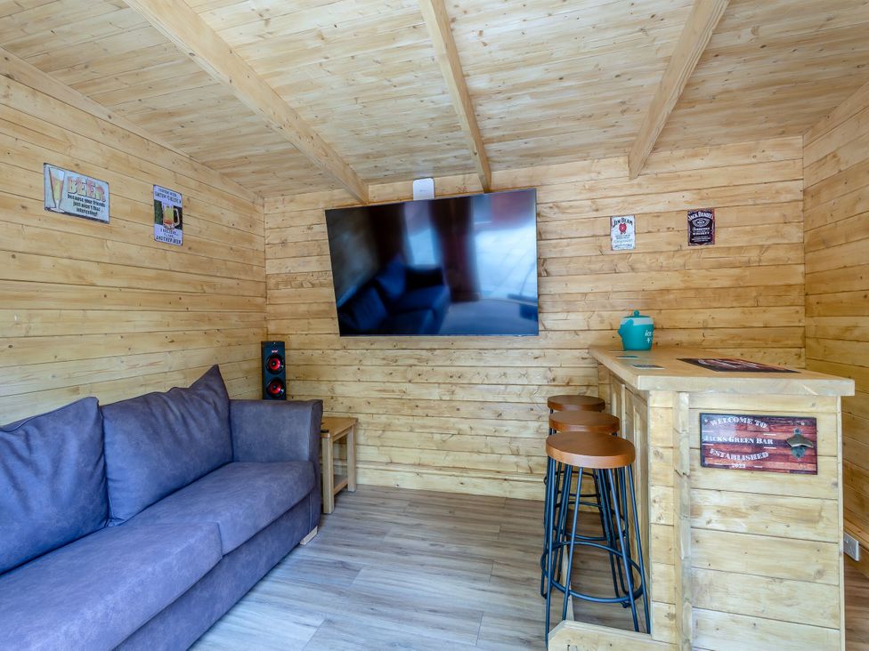 A snug with a sofa and bar area at The Cottage in Kings Cliffe