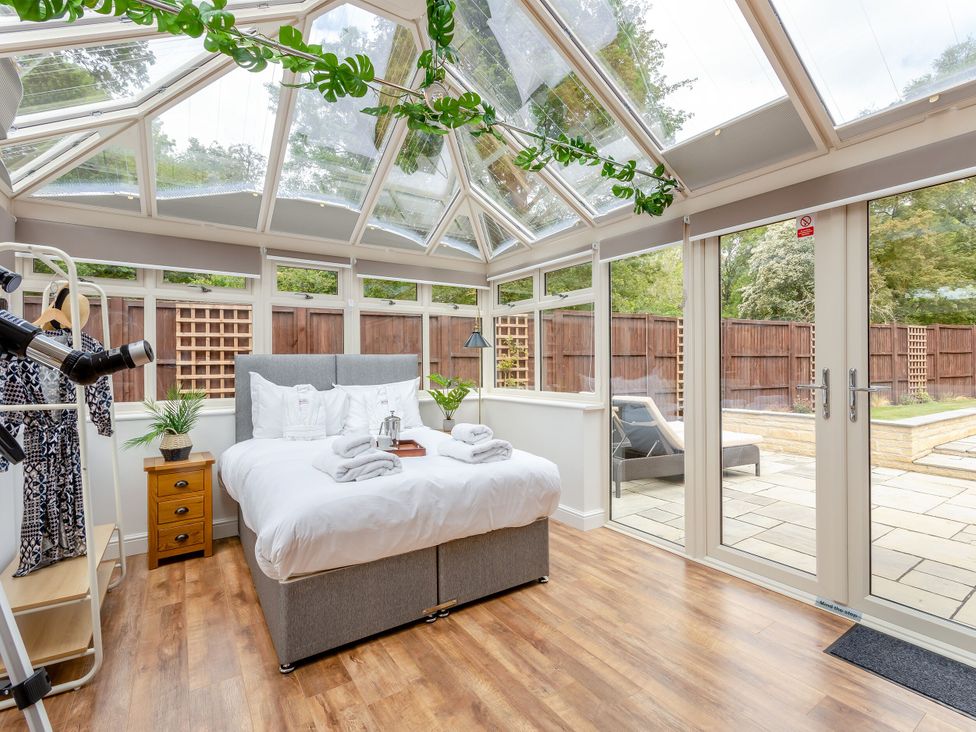 A bedroom with a bed and bedside table in The Cottage in Kings Cliffe