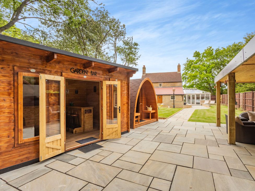 A garden bar and patio with seating at The Cottage in Kings Cliffe