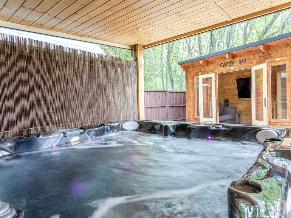 An outdoor area with a hot tub and a garden bar at The Cottage in Kings Cliffe