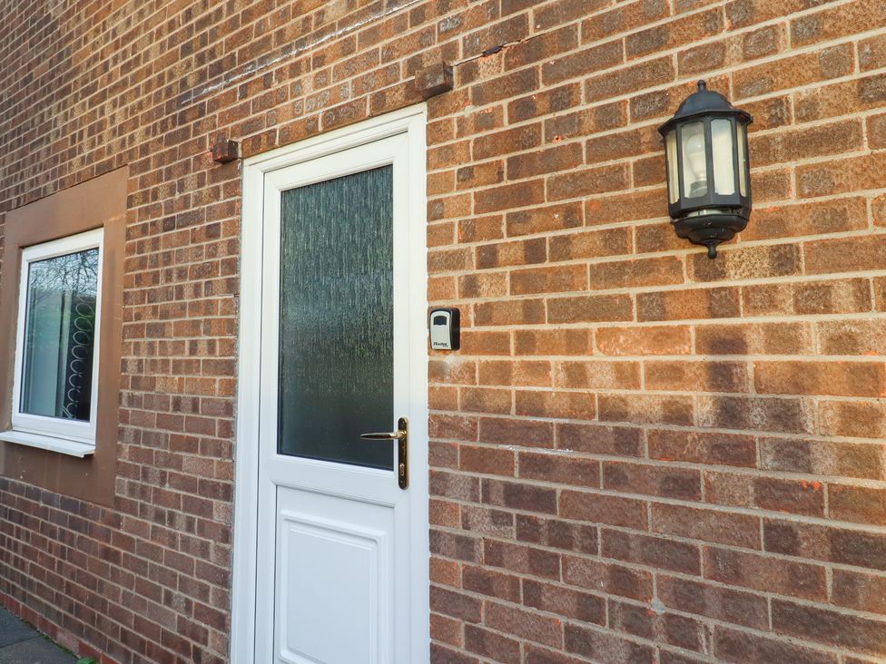 An exterior view showing a front door and window at Beadlin cottage Beadnell