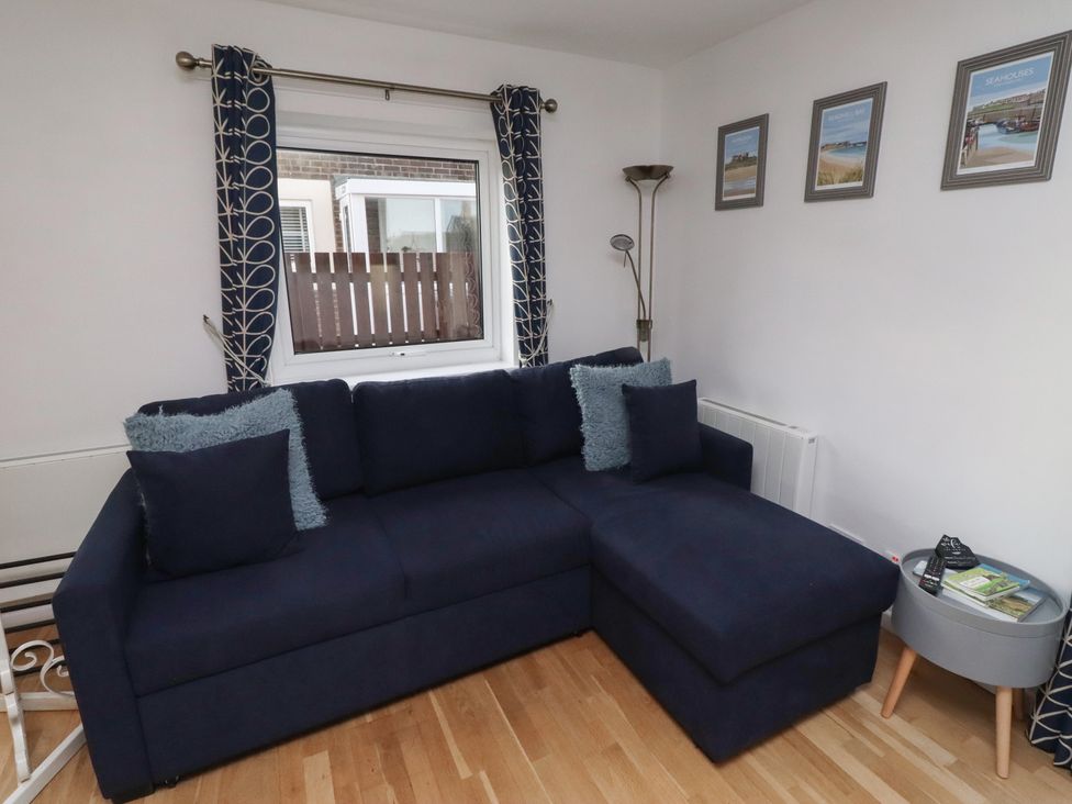 A living room with a sofa and decorative items at Beadlin cottage Beadnell