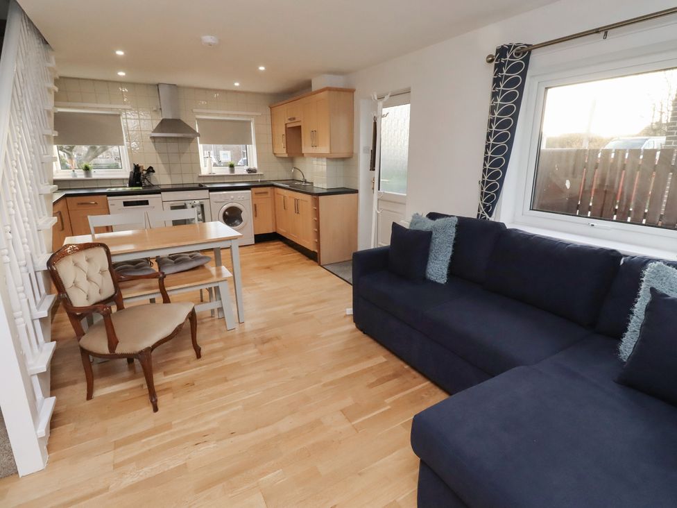 A kitchen with a dining area and a sofa at Beadlin cottage Beadnell