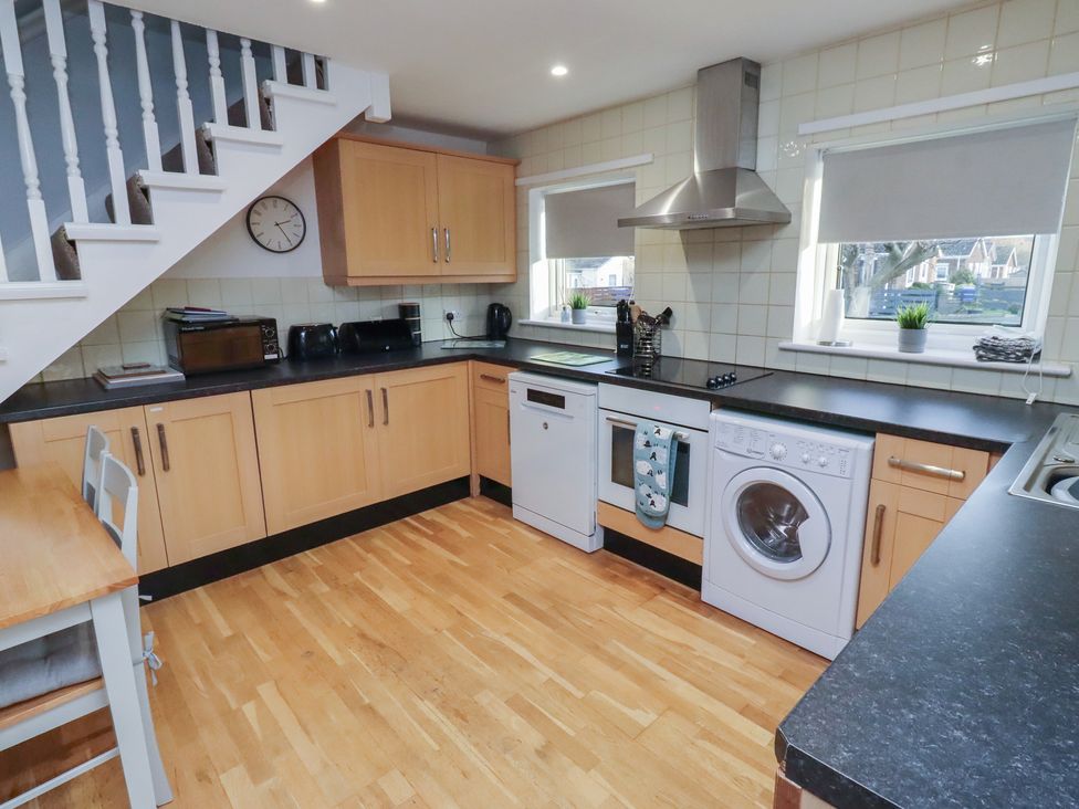 A kitchen with appliances and a table at Beadlin cottage Beadnell